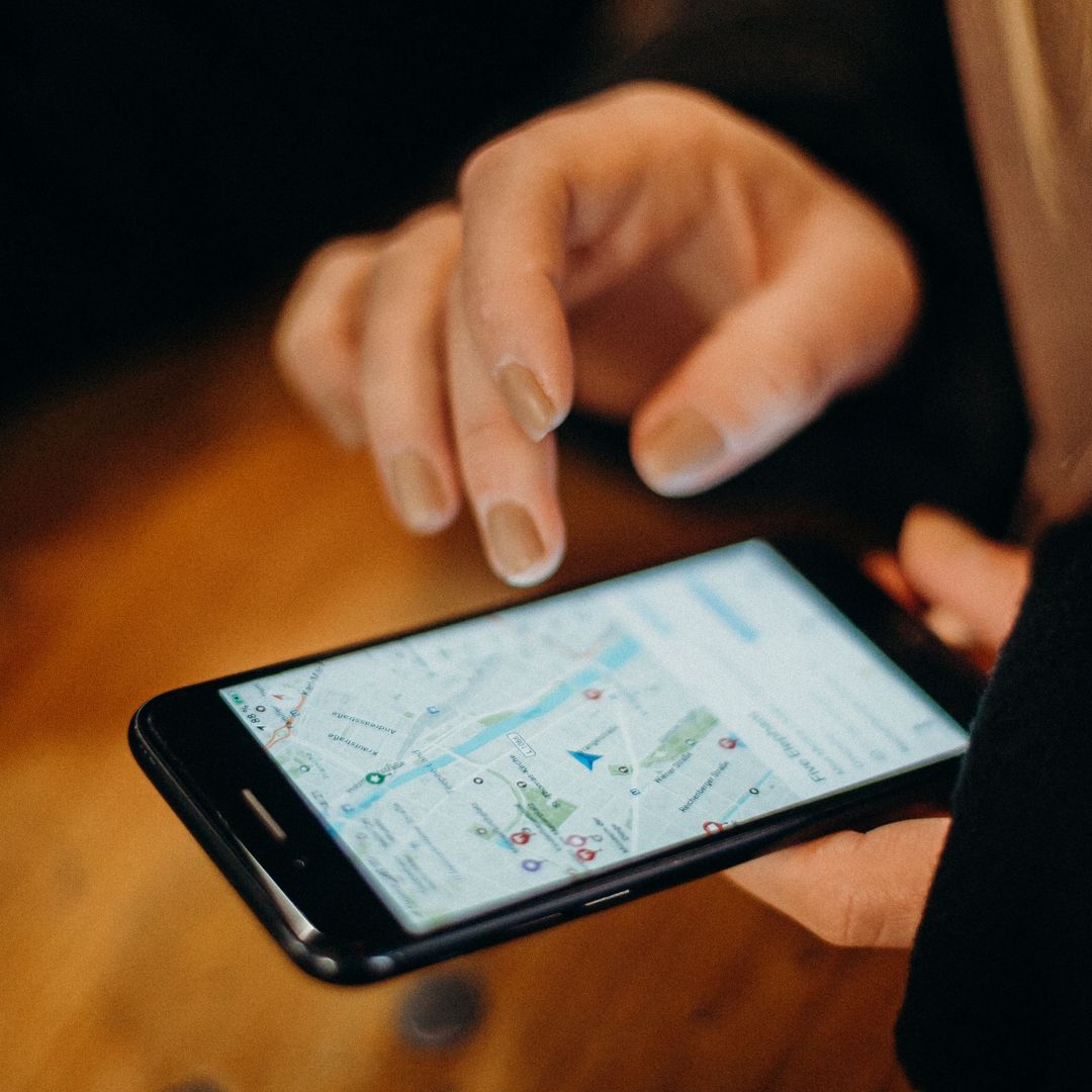 Main tenant un smartphone qui affiche une carte de navigation